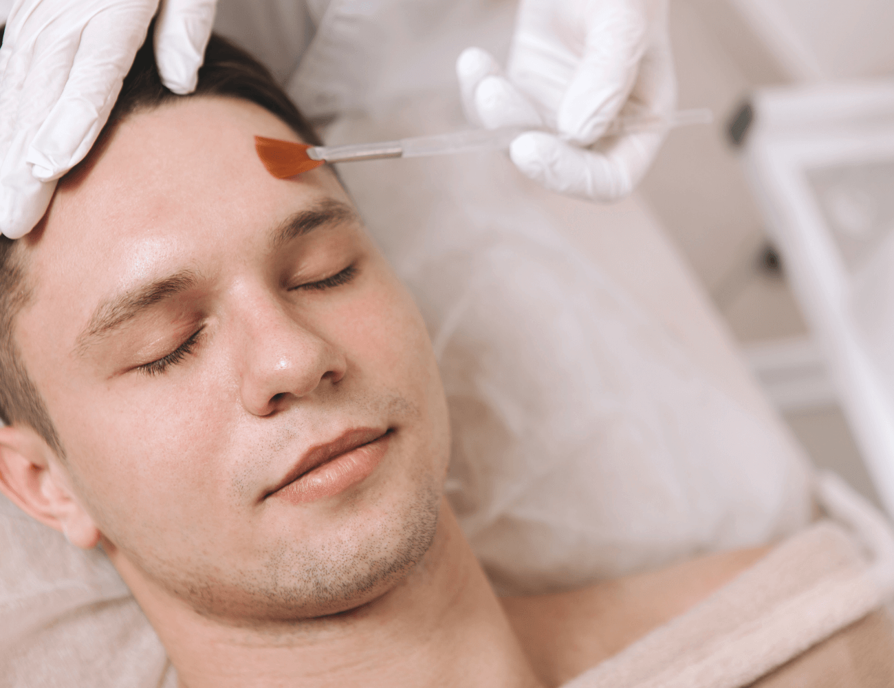 Man receiving a skincare treatment at a professional salon.