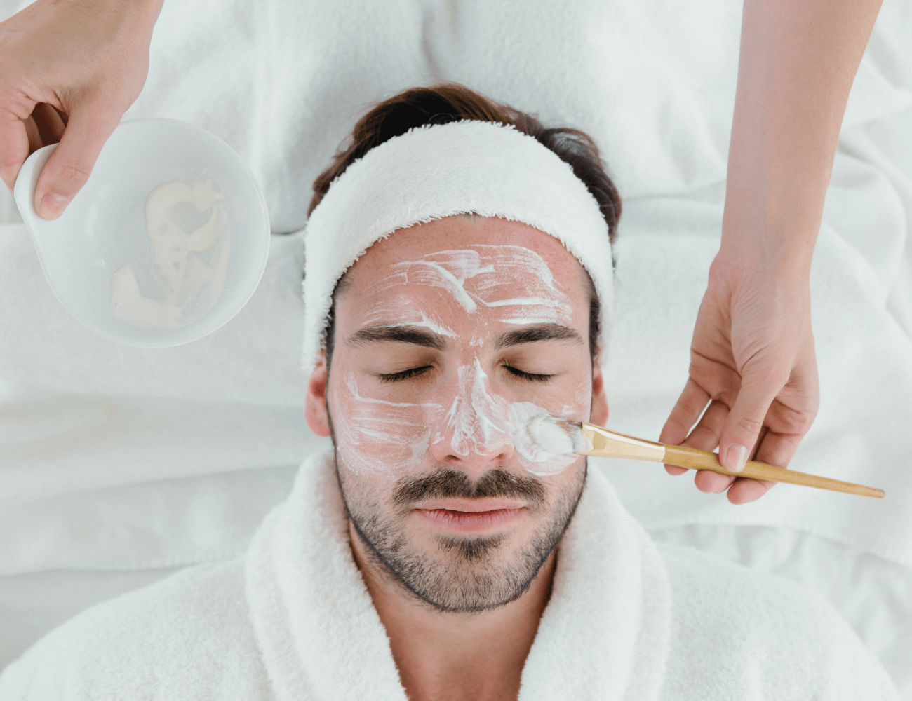 A man receiving a professional facial treatment at a spa for glowing, healthy skin.