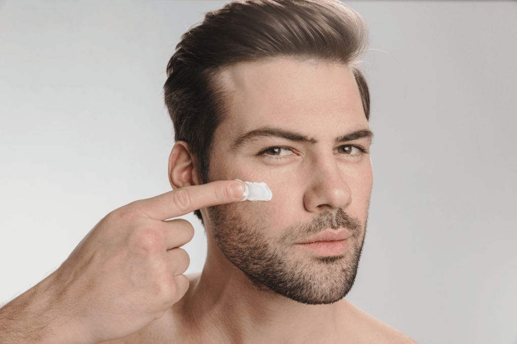 Man applying anti-aging cream on his face, highlighting Sculptra treatment benefits.
