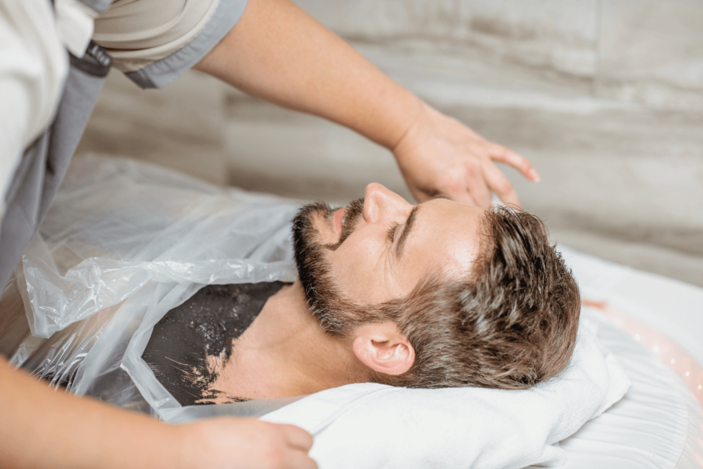 A man enjoying a detoxifying body wrap treatment at BossBeautyBar.