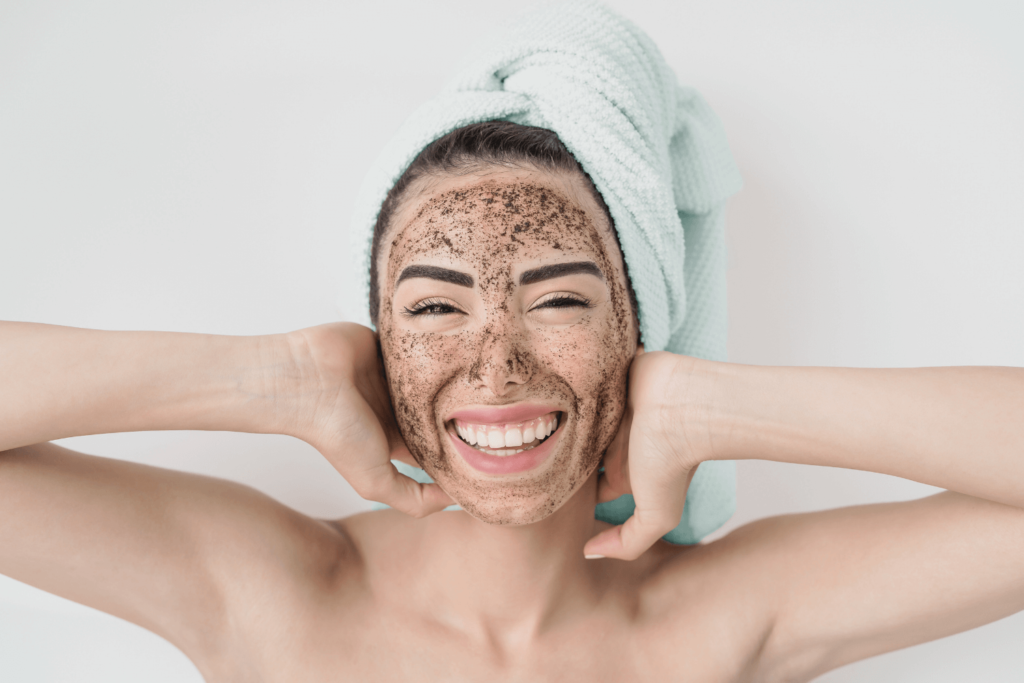 A woman smiling with a face scrub during the Face and Neck Polishing treatment at BossBeautyBar.