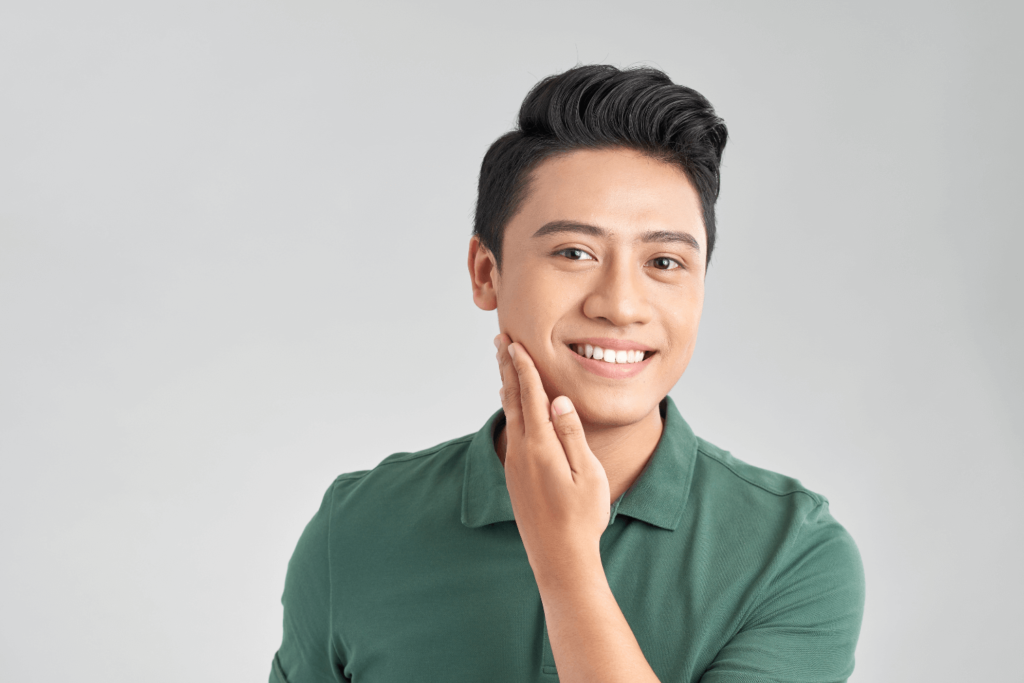 A man gently touching his smooth, rejuvenated face after proline therapy.