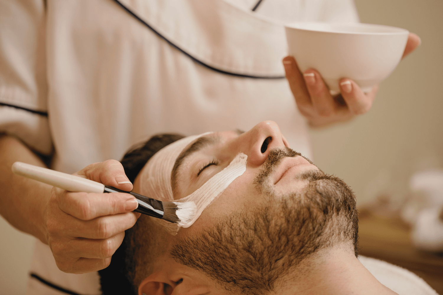 student practicing facial treatment on male client